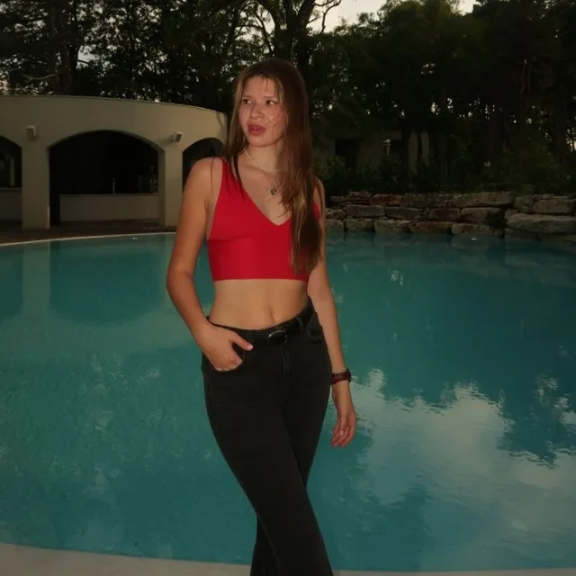 daria today, by a pool, in a red top